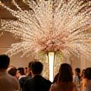 Guests admiring Ikebana arrangements at wedding.